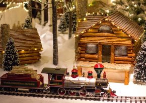 Christmas train model net to the wooden house. Source: Photo by John Matychuk on Unsplash
