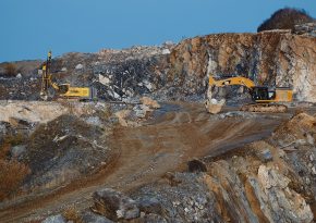 Drilling rig and excavator at the bench. Source: https://unsplash.com/photos/yellow-and-black-excavator-on-brown-rocky-mountain-during-daytime-bQ0FtTrcwwI