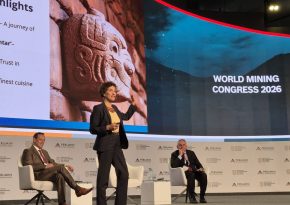 In the picture there is woman on stage. Behind her on a interactive wall is sign: World Mining Congress 2026.
